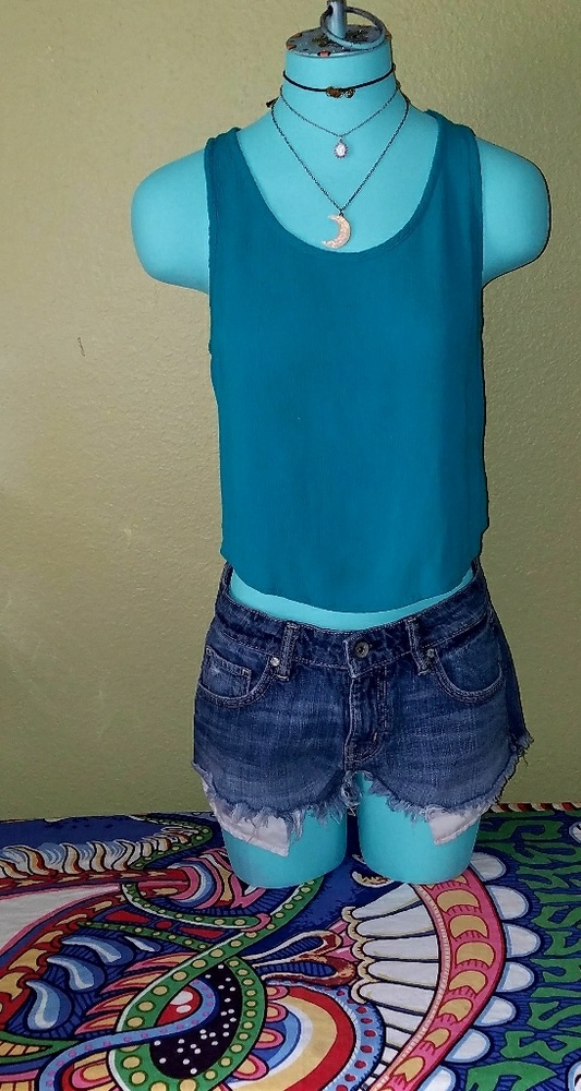 Dark turquoise crop top with knot detailing.
